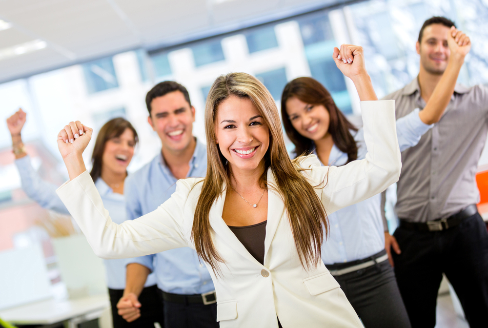 Successful business team with arms up at the office